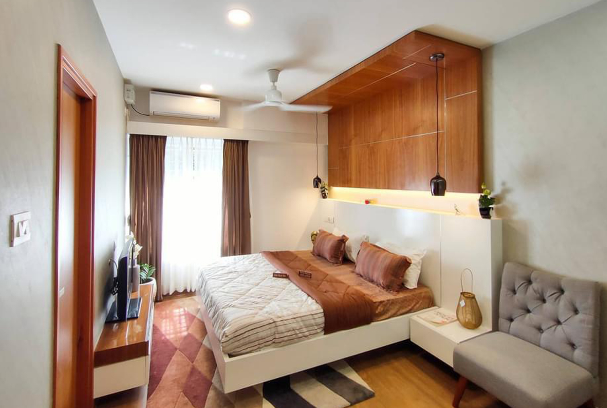 Cozy bedroom featuring a wooden headboard, pendant lights,
						 neutral bedding, and natural light from a large window.