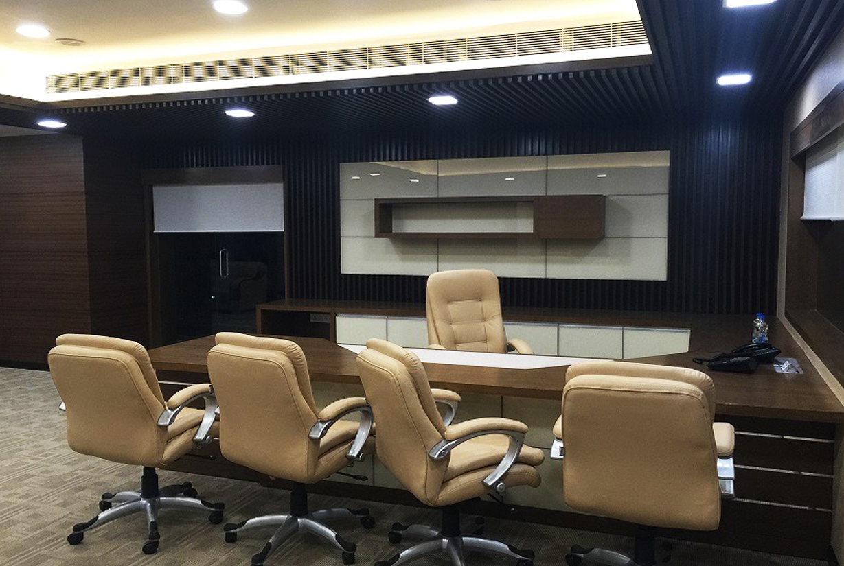 Executive office interior with beige leather
						 chairs, wooden desk, and integrated shelving