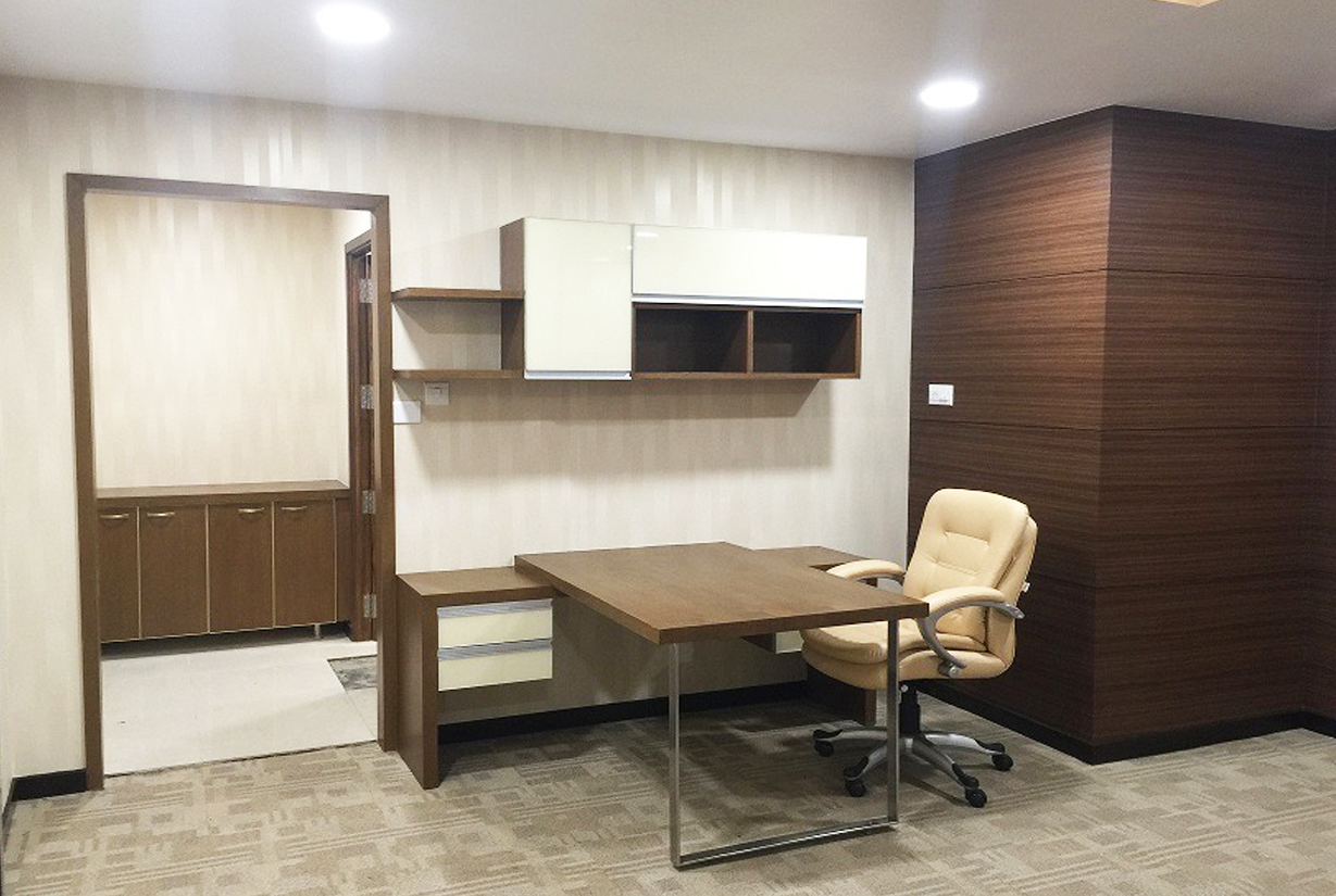 Private office design with a wooden desk, beige
						 ergonomic chair, and built-in storage cabinets