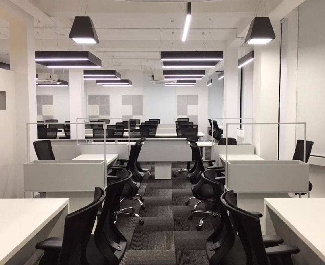 Modern commercial office space,
								 black chairs, white desks, contemporary lighting, open layout design