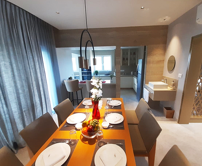 Dining room with a long wooden table, modern pendant lights,
								 elegant table setting, and neutral tones.