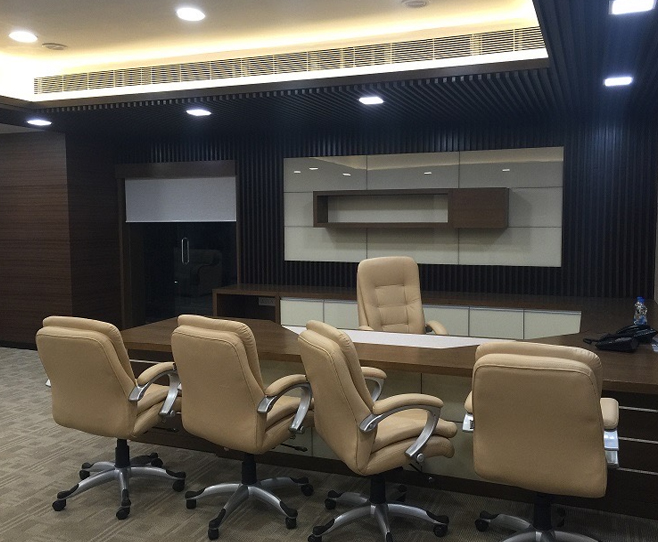 Executive office space with tan leather chairs, wooden desk,
								 modern cabinetry, and sleek lighting.