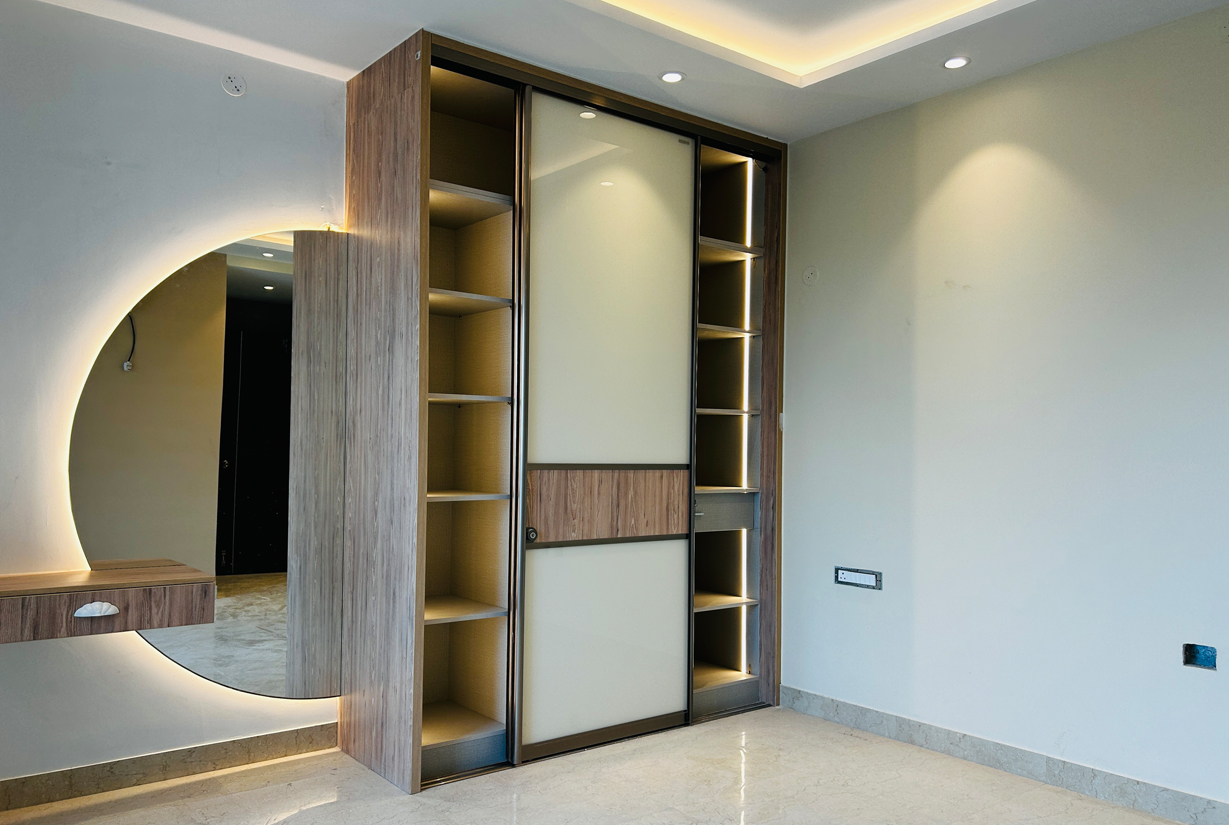 Custom-built wardrobe with integrated lighting, modern sliding doors,
						 round mirror design in residential interior